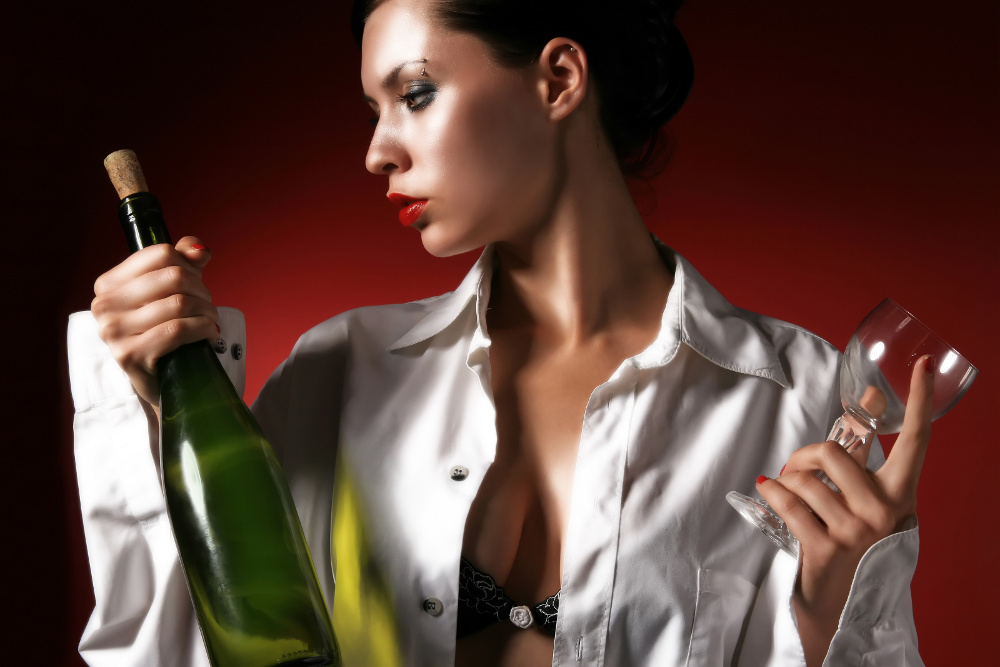 Одинокая женщина в белой рубашке с бокалом вина