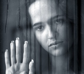 Девушка грустит у окна